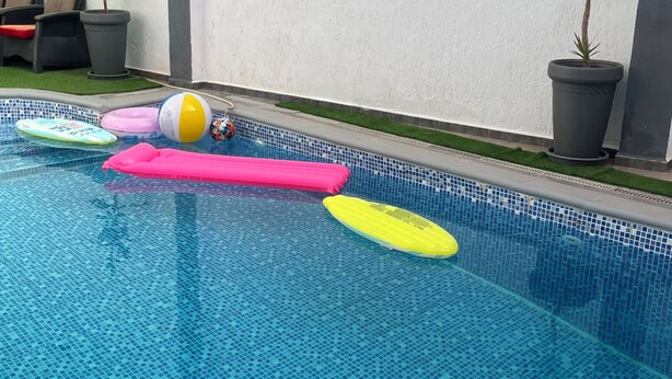 En swimmingpool med ett kaklat botten och några föremål som flyter i vattnet.