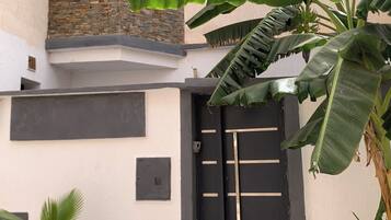 Un bâtiment avec une porte noire, une petite fenêtre et un mur en pierre.