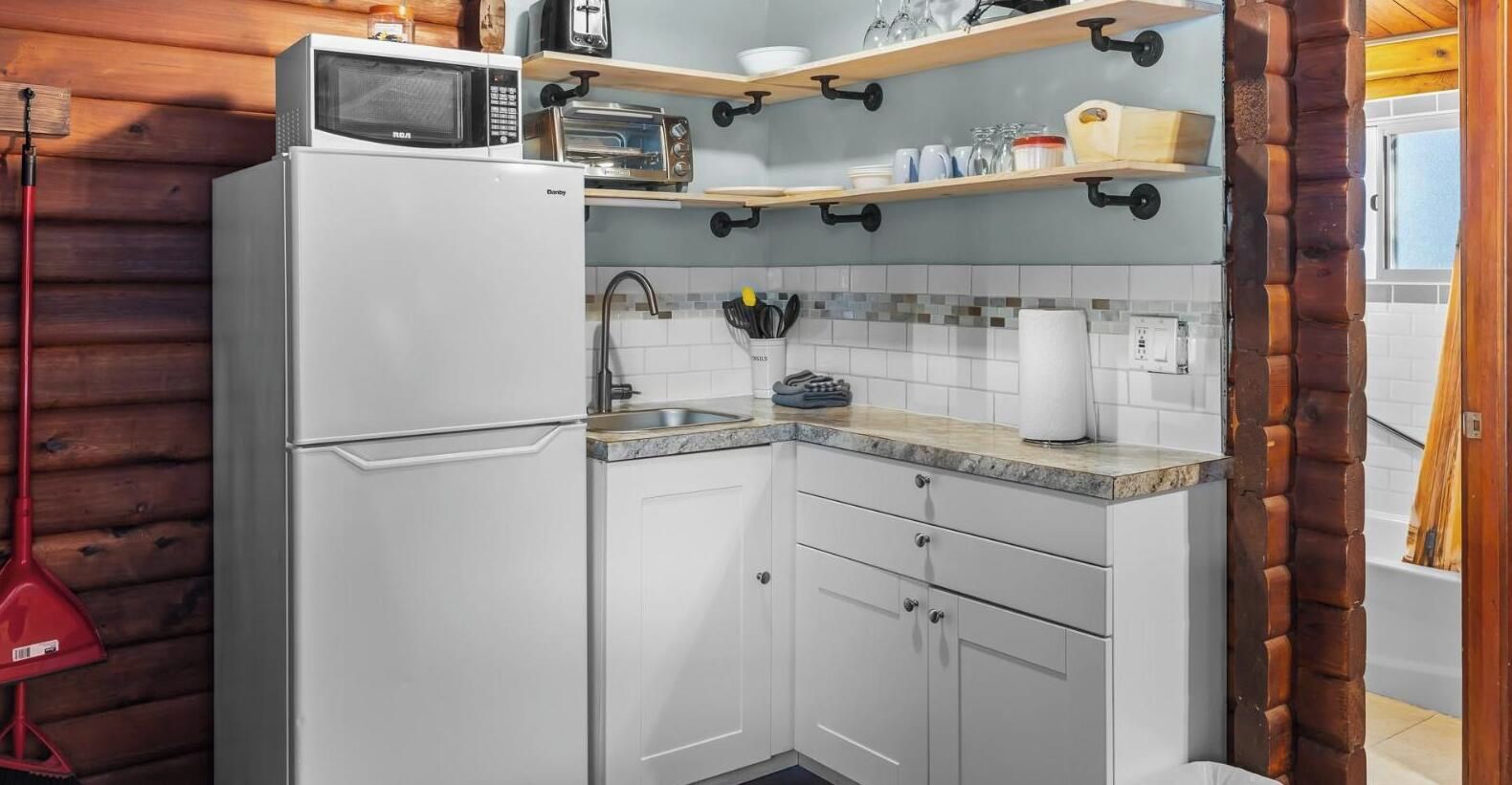 Une cuisine compacte équipée d’un four à micro-ondes, d’un grille-pain et d’un évier.