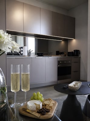 A modern kitchen with a built-in oven, a coffee maker, and a dining area with a table set for a meal.