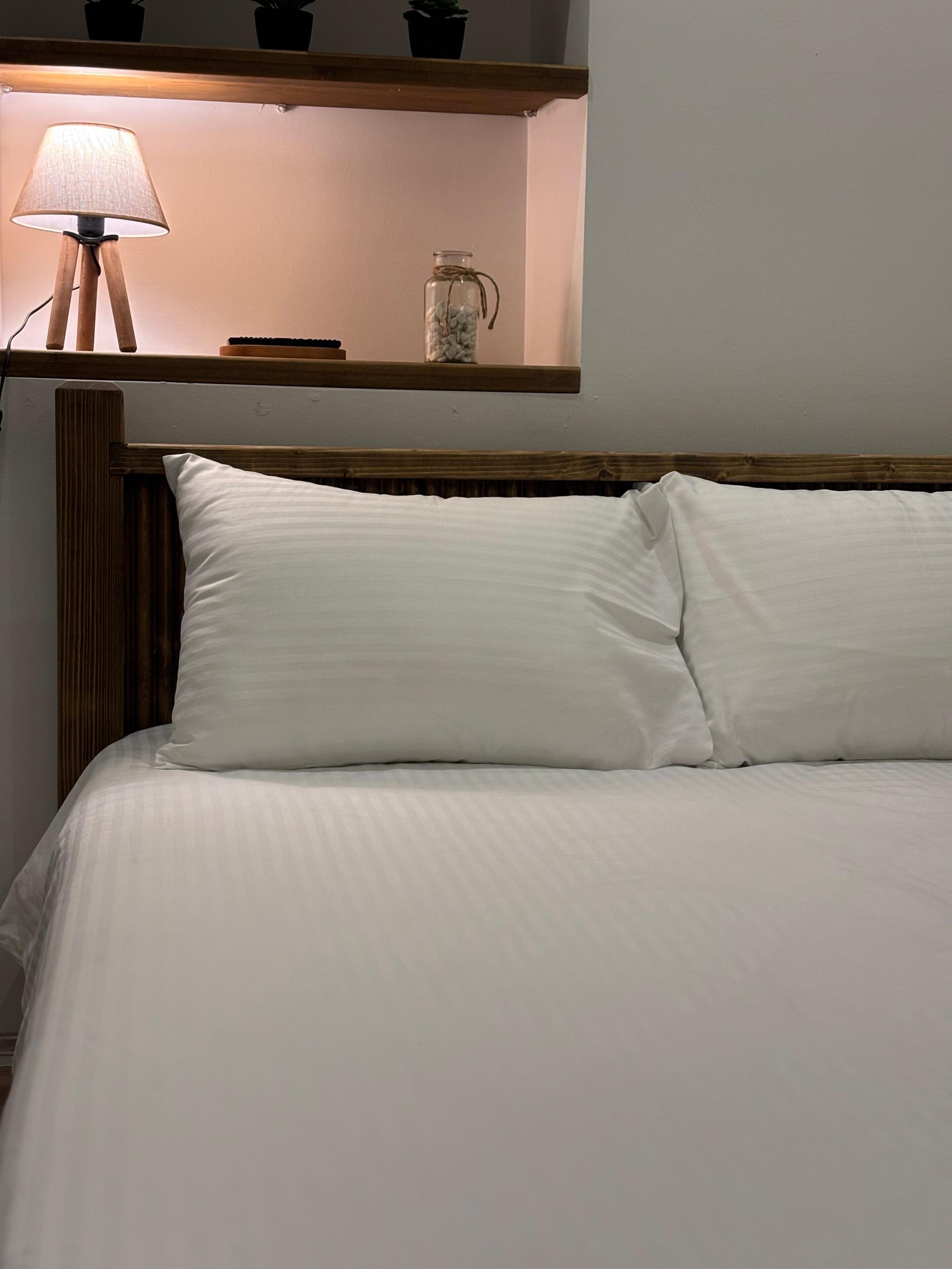 A bed with white bedding and a wooden headboard.