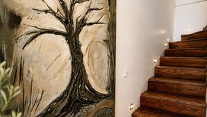 A staircase with wooden steps and a large abstract painting on the wall.