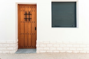 A wooden door with a metal handle and a window with a roller shutter. - Pool house near Andalusia's main cities (Luque)
