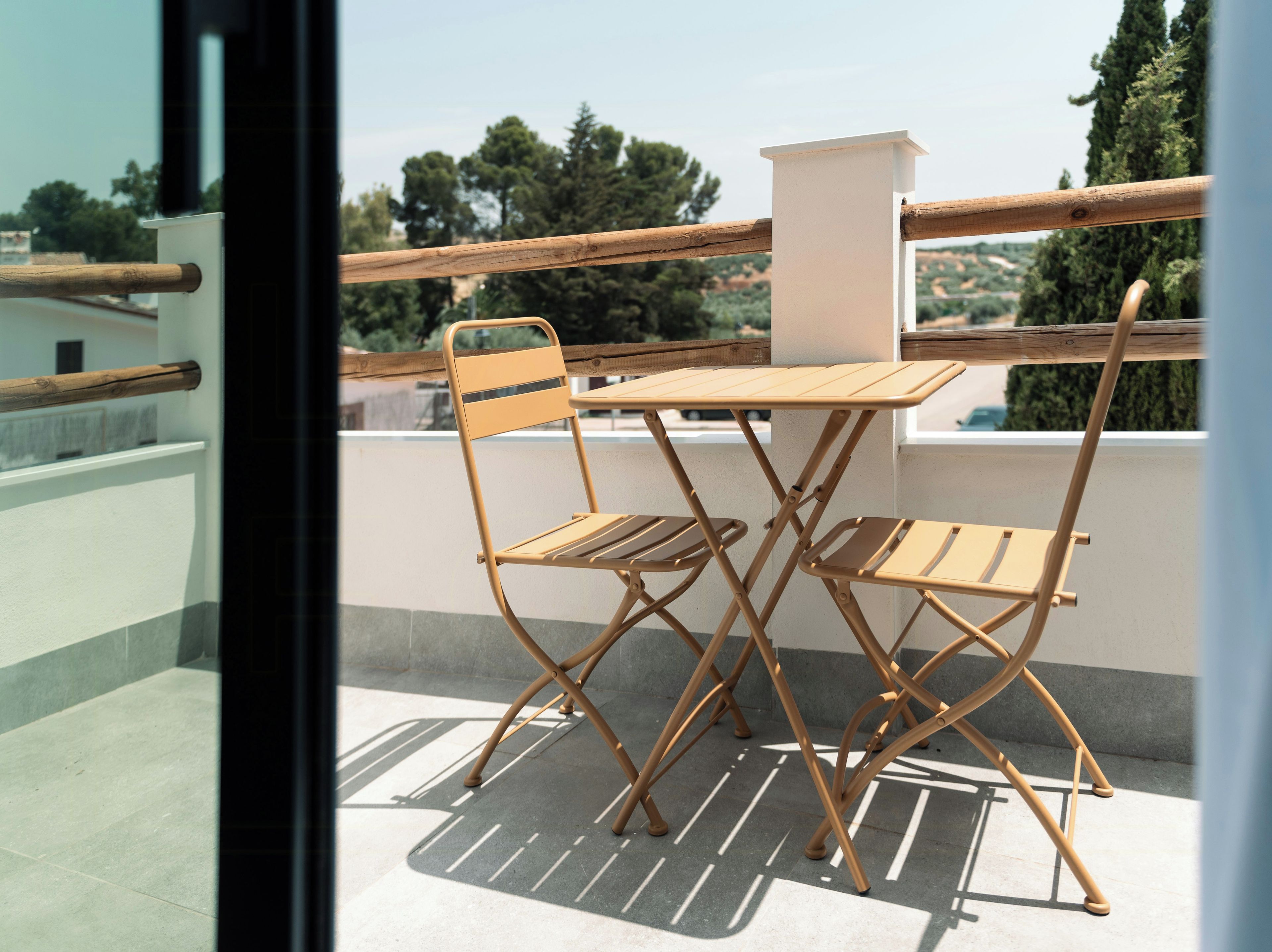 A balcony with a table and two chairs.
