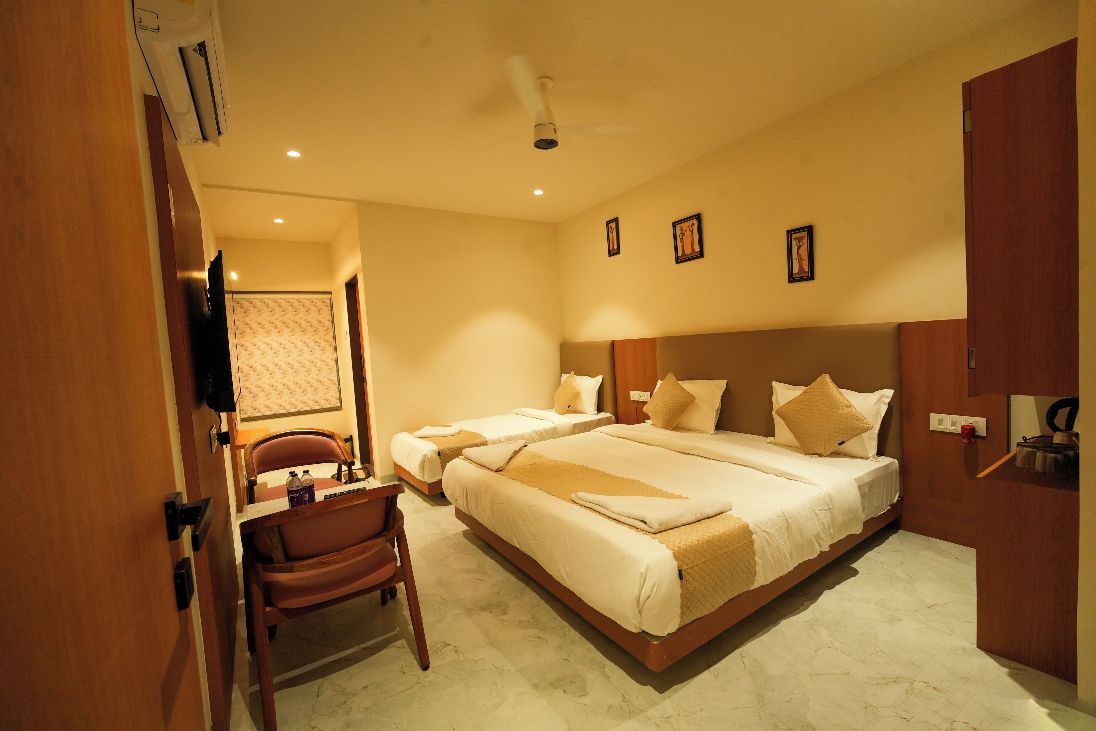 Une chambre d’hôtel avec un grand lit, un bureau, une chaise et un téléviseur.