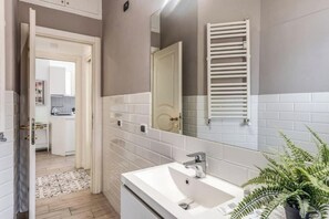 A bathroom with a white sink, a mirror, and a towel rack. - Domus Heroas near Vatican (Rome)
