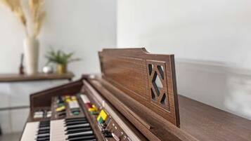 A piano with a wooden finish and a decorative cut-out design on the side.