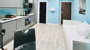 Una habitación de hotel moderna con kitchenette, una cama y un baño.