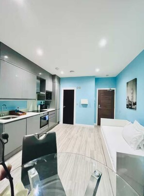 A modern hotel room with a kitchenette, a bed, and a bathroom. - Milburn Residents (Oldbrook)