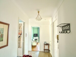 A hallway with a door leading to a room with a television and a small table. - Spacious 3-bedroom apartment in delightful Cannes with AC - LES BANANIERS (Cannes)
