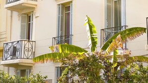 A multi-story building with balconies, shutters, and decorative iron railings. - Spacious 3-bedroom apartment in delightful Cannes with AC - LES BANANIERS (Cannes)