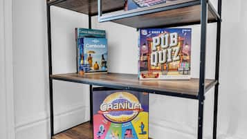 A bookshelf with three books: 'Cambodia' by David Attenborough, 'PUB Quiz' trivia game, and 'Cranium' family game.