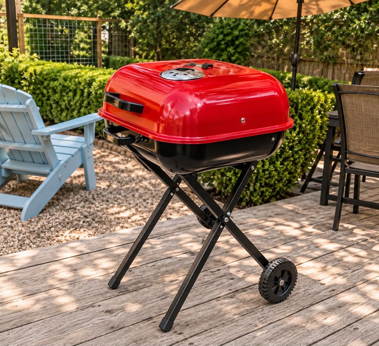 Een draagbare barbecue met wielen op een houten terras.