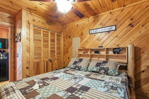 A cozy wooden room with a bed, a ceiling fan, and a sign on the wall. - Helen Cabin w/ Deck & Hot Tub 1/3 Mi to Main St (Helen)