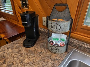 A kitchen with a Keurig coffee maker and a metal container holding coffee pods. - Helen Cabin w/ Deck & Hot Tub 1/3 Mi to Main St (Helen)