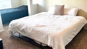 Quarto com cama, travesseiros e janela.