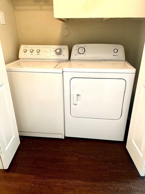 A laundry room with two stacked washers and a dryer.