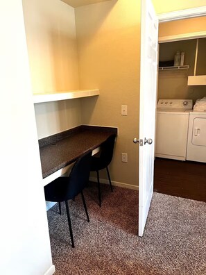A small laundry room with a washing machine, a dryer, and a countertop with chairs. - Modern Comfort Getaway- 2bd 1bath Free Parking (Woodland)