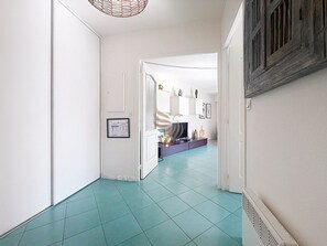 A hallway with a teal floor leading to a room with a white door. - Casa Port Latin: Terrace, Wi-Fi, beaches within walking distance (Fréjus)