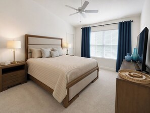 A bedroom with a bed, nightstands, a dresser, a ceiling fan, and a window with curtains. - New Designer Home · Complimentary Golf Cart · Prime Location in The Villages (Sumterville)