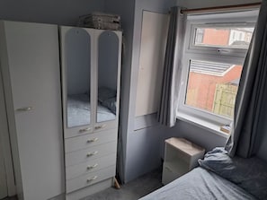 A bedroom with a wardrobe, a bed, a window, and a small bedside table. - 4 Bedroom House Sleeps 6 - Garden - Free Parking (Belfast)