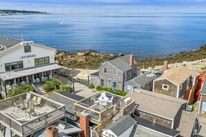 A coastal town with a prominent ice house and a view of the sea.
