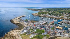 A coastal town with a marina, houses, and rocky shores.