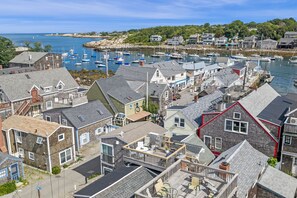 A coastal town with a marina, houses with various roof styles, and a clear view of the sea.