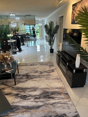 Un hall amplio con suelo de mármol, una recepción y una escalera.