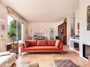 Ein Wohnzimmer mit einer Couch, einem Kamin und einem Bücherregal.