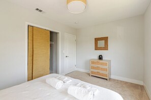 A bedroom with a bed, a wardrobe, a dresser, and a mirror. - The Cozy California Bungalow (Inglewood)
