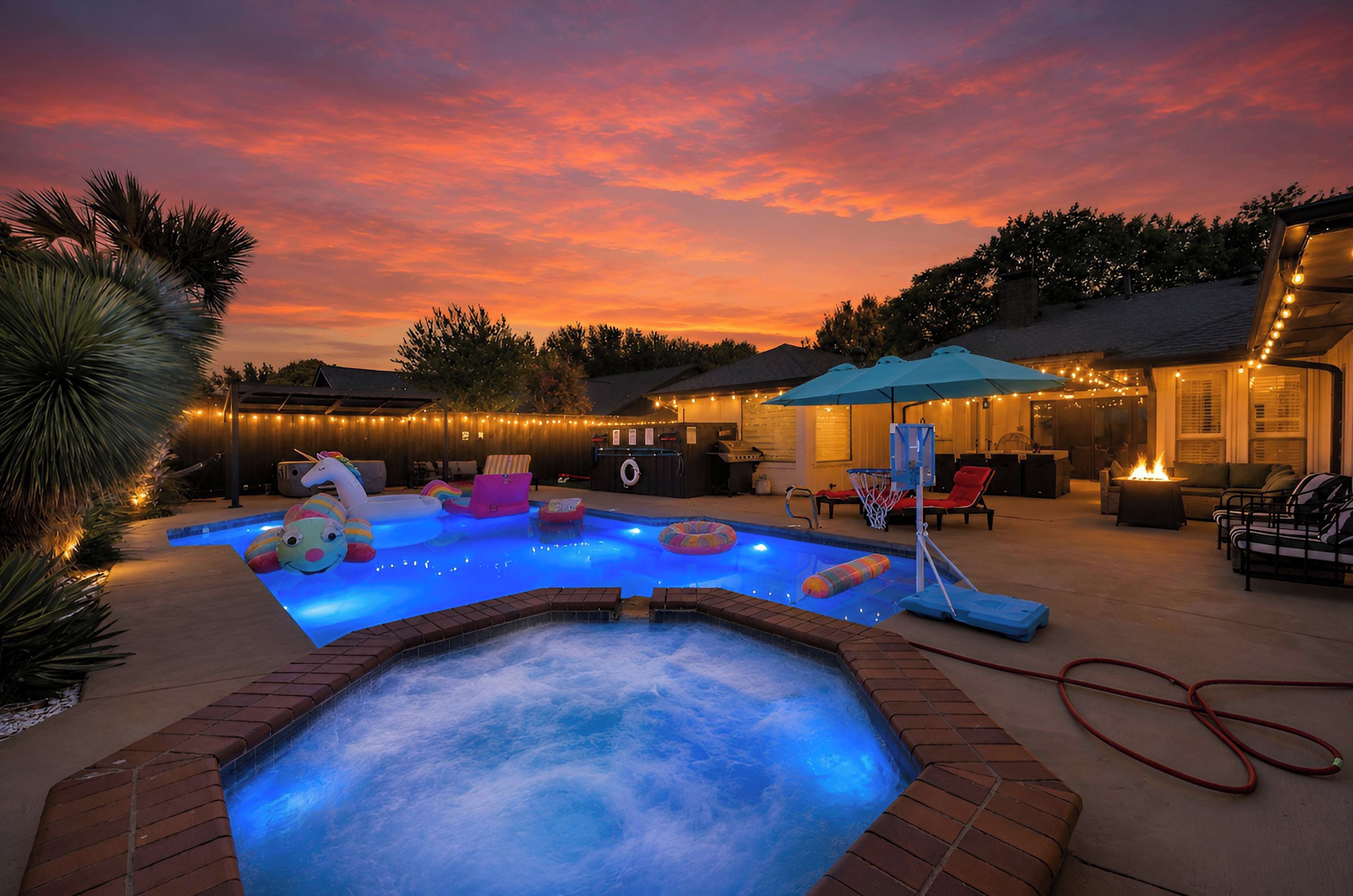 Een achtertuin met een zwembad, een jacuzzi en een terras.