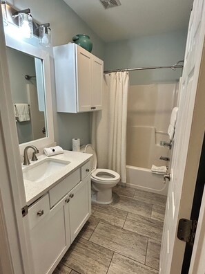 A bathroom with a sink, toilet, bathtub, and shower curtain. - Charming 30A Beach Home, 5Min walk to Gulf, on front of the community pool, A/C (Santa Rosa Beach)