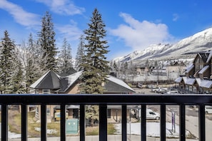 A residential area with snow-covered houses and a mountain backdrop. - The Canmore Mountain View Retreat with Heated Pool & Hot Tub (Canmore)