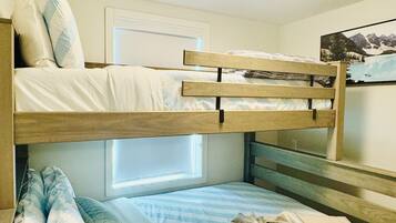 A bunk bed with a window, a ceiling light, and a wall-mounted picture.