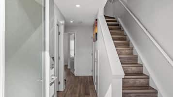 Eine moderne Treppe mit Holzhäuschen und weißen Wänden.