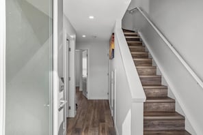 A modern staircase with wooden steps and white walls. - The Canmore Mountain View Retreat with Heated Pool & Hot Tub (Canmore)
