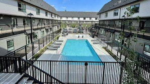 Une cour avec une piscine, entourée d’immeubles à plusieurs étages dotés de balcons.
