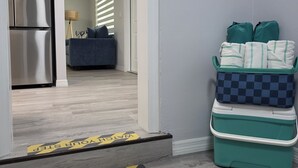 Ein Flur mit einem Kühlschrank, einer Couch und einem Mülleimer.