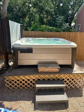 Een hottub met een houten terras en een trap er naartoe.