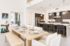 Eine moderne Küche mit dunklen Holzschränken, Edelstahlgeräten und Pendelleuchten.