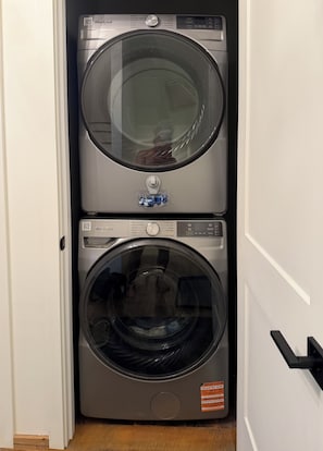 A Whirlpool stacked washer and dryer unit in a hallway. - Modern Rustic Black Oak Tower – Treetop Views (Stanton)