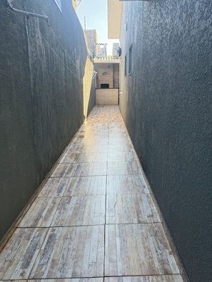 A narrow alleyway with a tiled floor leading to a building entrance. - Charming 2-bedroom house in serene Foz do Iguaçu with AC (Foz do Iguaçu)