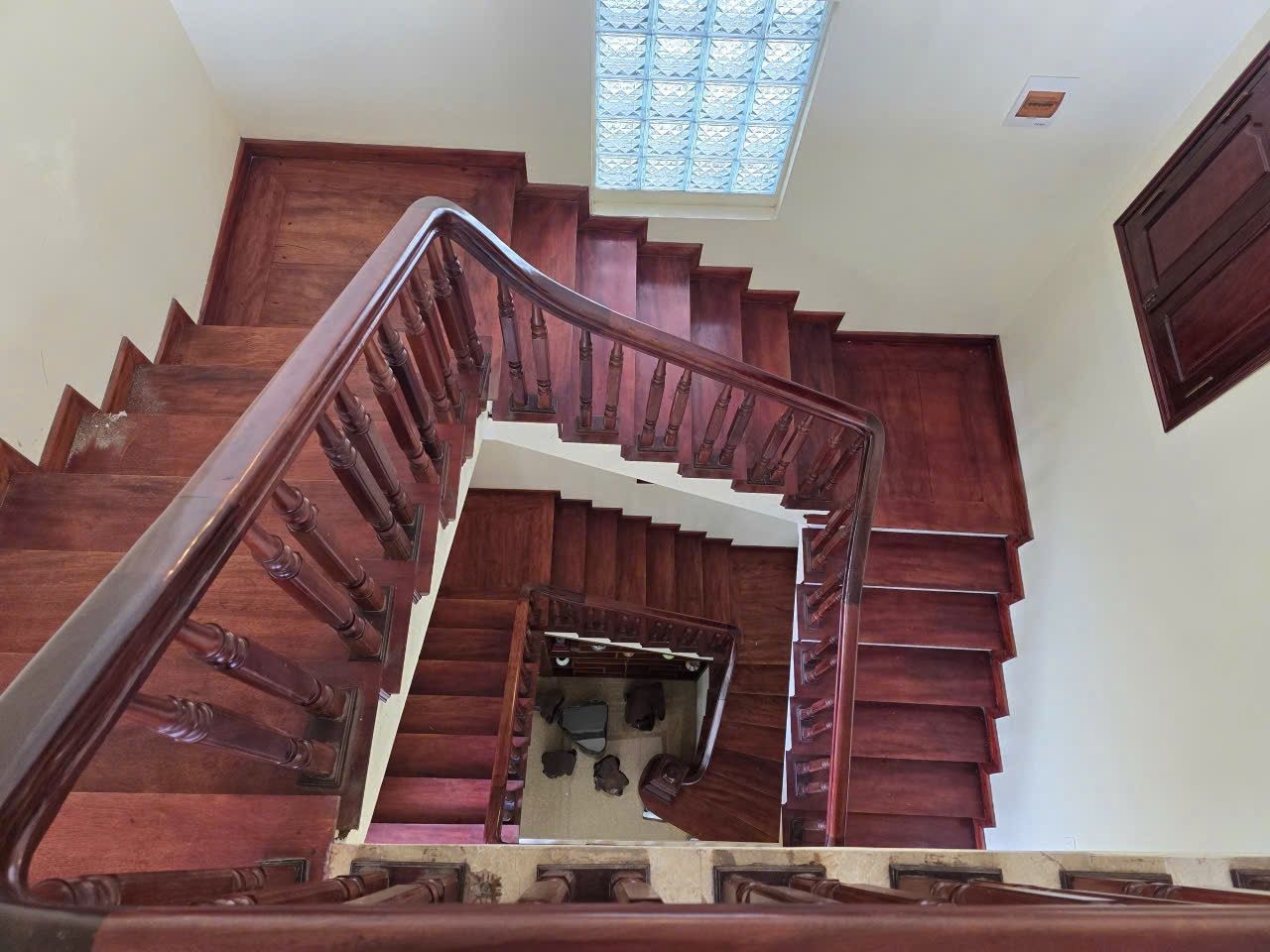 A wooden staircase with a handrail leading to a landing.