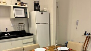 Ein Essbereich mit einem Holztisch, gedeckt für vier Personen, umgeben von Stühlen.