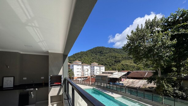 Ein Balkon mit Blick auf einen Swimmingpool, einen Essbereich und eine gebirgige Landschaft im Hintergrund.