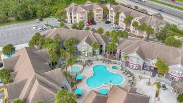 A hotel with multiple buildings, a swimming pool, and a parking lot.