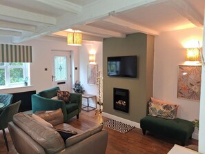 Ein Wohnzimmer mit Kamin, Fernseher und einer Couch.