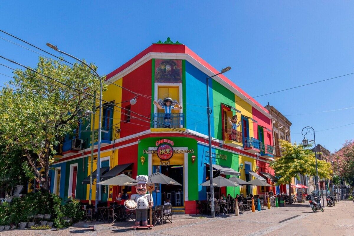 A colorful building with a cafe and outdoor seating area.