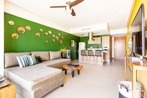 A living room with a sofa, coffee table, and a dining area with chairs.